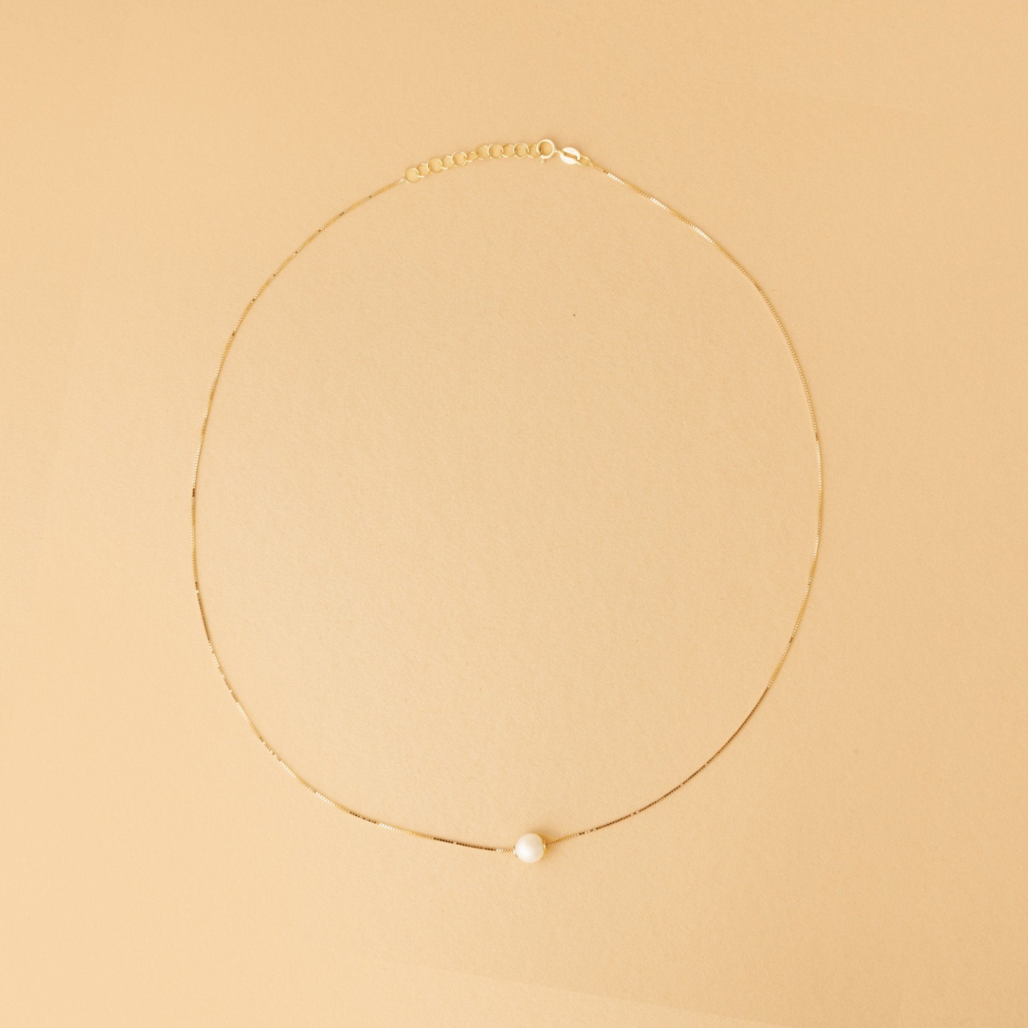 Kvinna halsband – 14K guld med sötvattenspärla. Stilrent halsband med justerbar längd och naturlig lyster. Designad för en tidlös smyckegarderob.