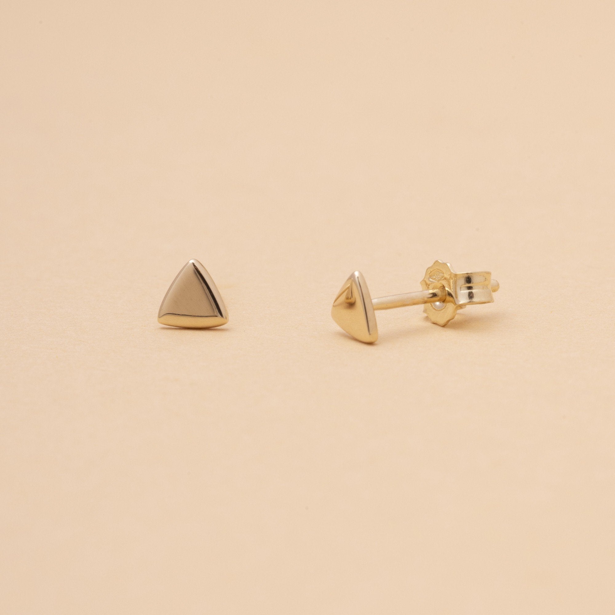 Altare – triangelformade stiftörhängen i 14K massivt guld. En minimalistisk hyllning till det som är heligt i vardagen. Symbol för riktning, balans och cirkulärt värde.