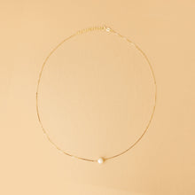 Kvinna halsband – 14K guld med sötvattenspärla. Stilrent halsband med justerbar längd och naturlig lyster. Designad för en tidlös smyckegarderob.



