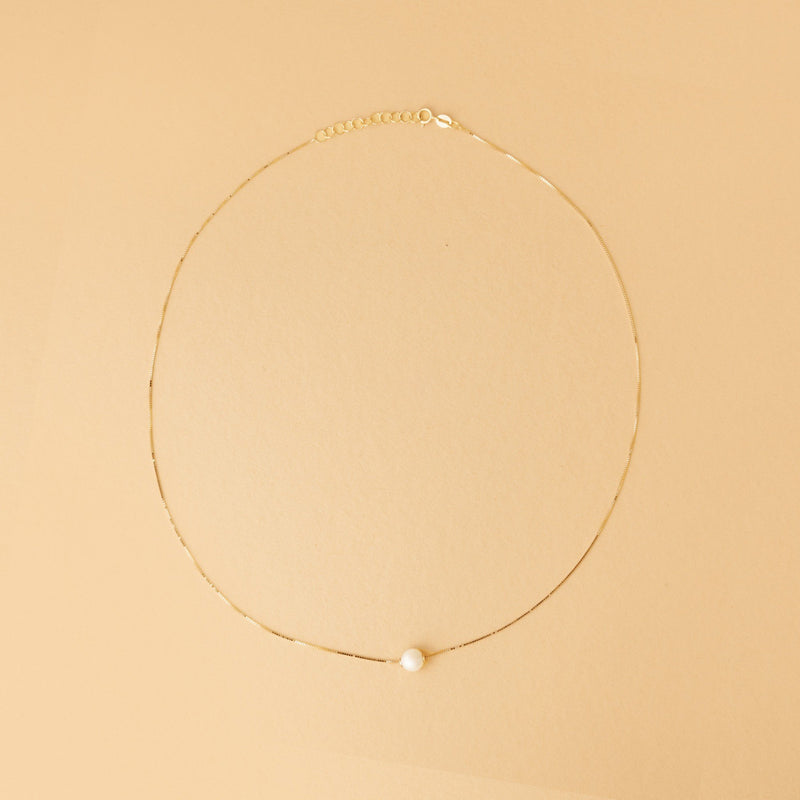 Kvinna halsband – 14K guld med sötvattenspärla. Stilrent halsband med justerbar längd och naturlig lyster. Designad för en tidlös smyckegarderob.



