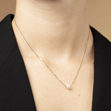 Närbild: Kvinna halsband i 14K guld med sötvattenspärla – bärs på modell. Elegant smycke för vardag och ceremoni. Perfekt present eller arvegods.

