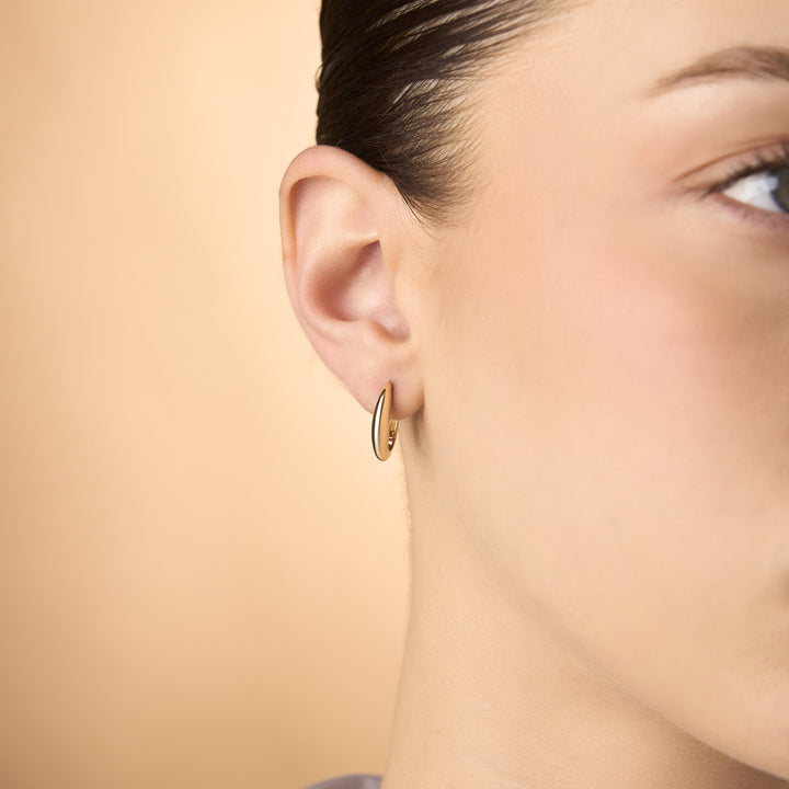 Arcus Hoops Örhängen från Nock Studios bärs av modell – reflekterar ljus och rörelse i örat.

