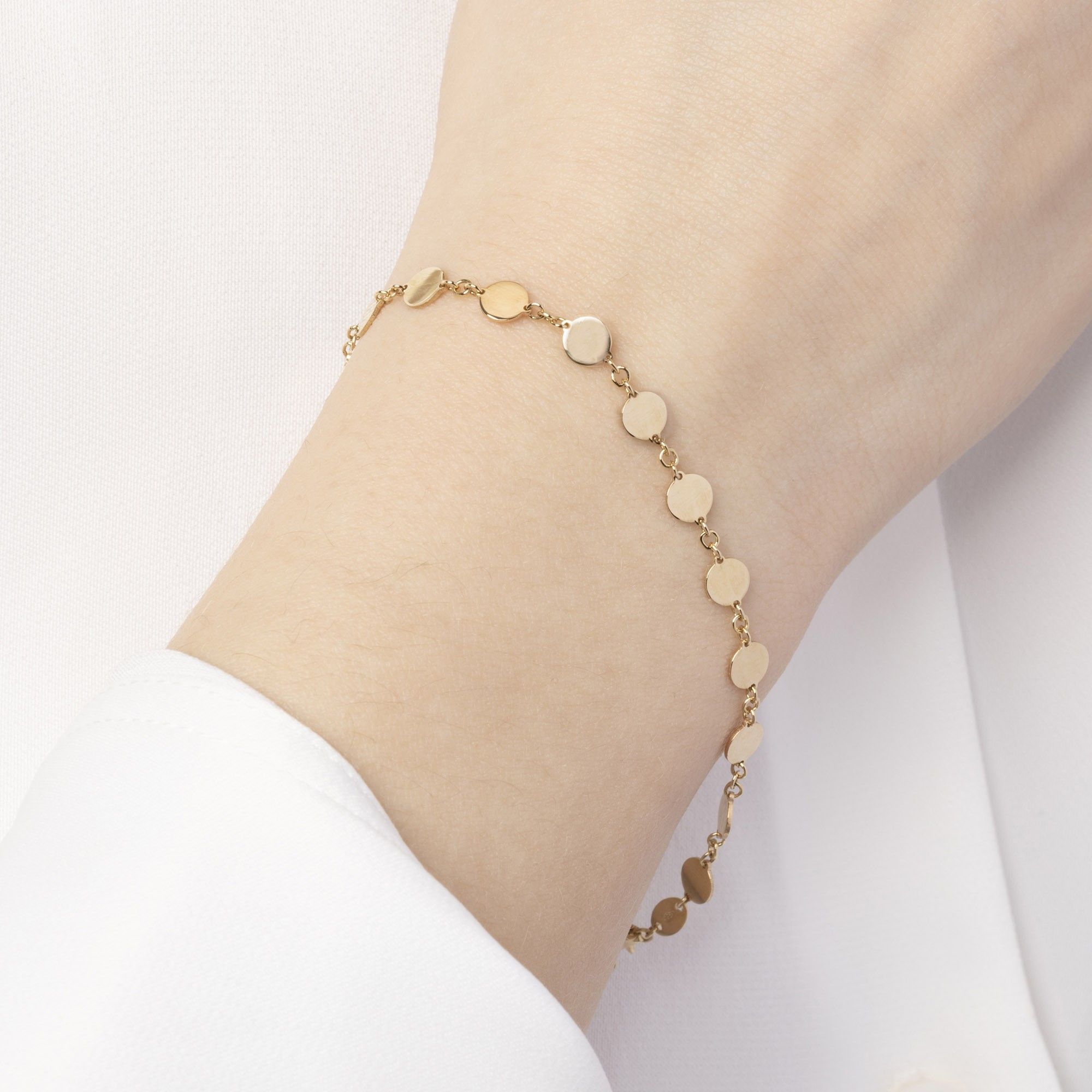 Armband i 14K guld på handled – Gyllene Cirkel från Nock Studios, elegant cirkeldesign för vardag och layering.