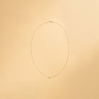 Innersta – hjärthalsband i 14K guld från Nock Studios, fotograferat på ljus bakgrund för att framhäva smyckets minimalistiska design och glans.