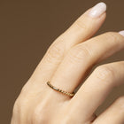 Lätta viskningar – sfärisk ring i 14K guld på hand, minimalistisk och taktil design från Nock Studios.