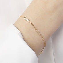Momentum Armband i 14K massivt guld på handled – minimalistisk design med rektangulära länkar, symboliserar balans och rörelse | Nock Studios