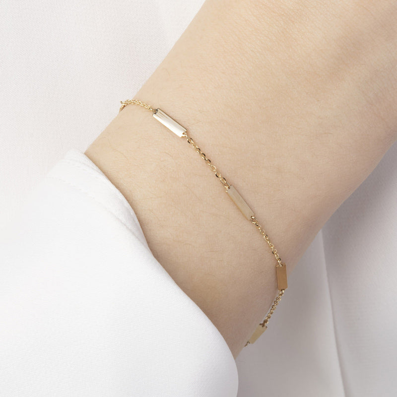 Momentum Armband i 14K massivt guld på handled – minimalistisk design med rektangulära länkar, symboliserar balans och rörelse | Nock Studios