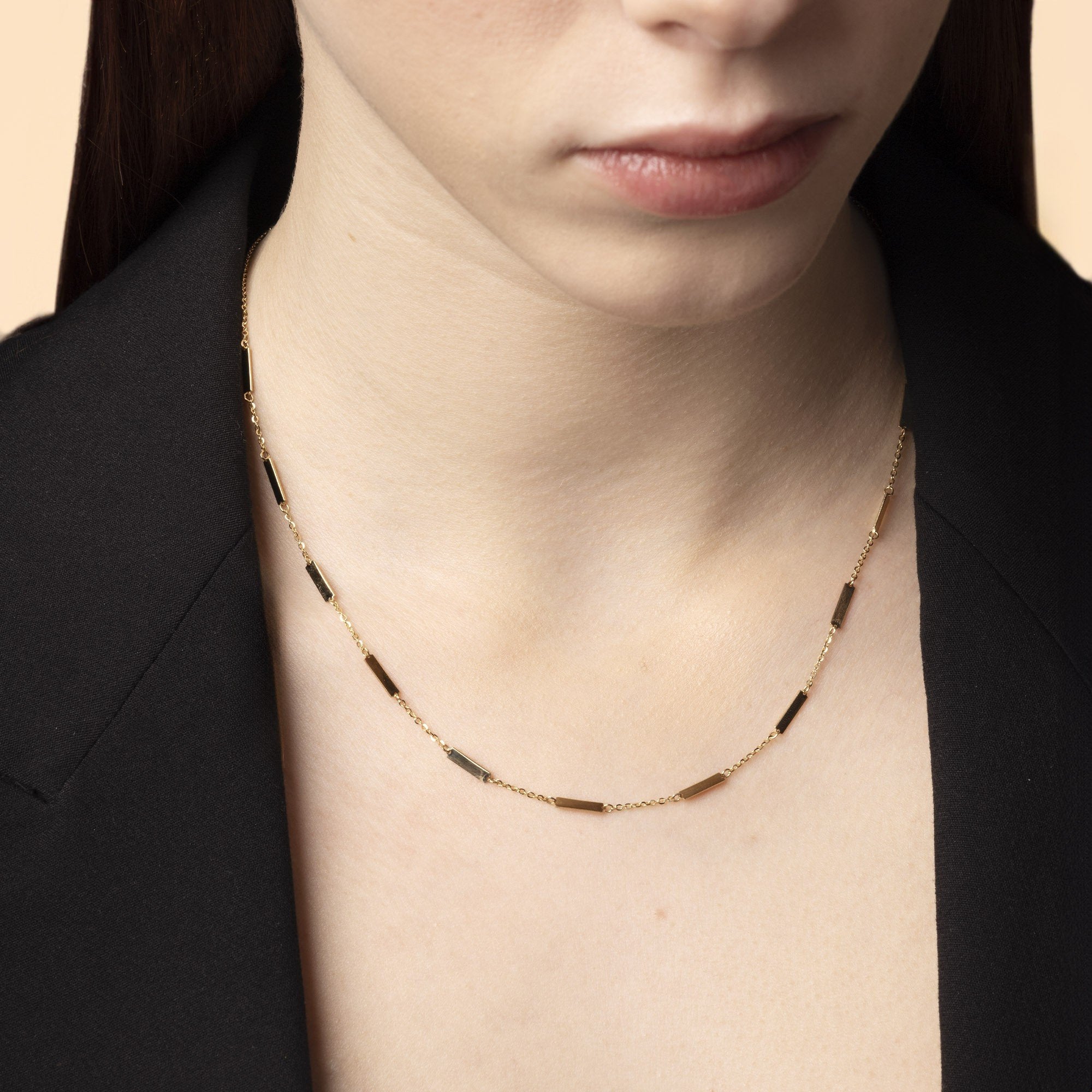 Momentum Halsband i 14K guld från Nock Studios, buren på modell – en stilren linje av rörelse och närvaro.