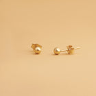 Nock Sfär 3 mm – sfäriska stiftörhängen i 14K guld. Subtil och minimalistisk design perfekt för stacking eller att bäras solo.