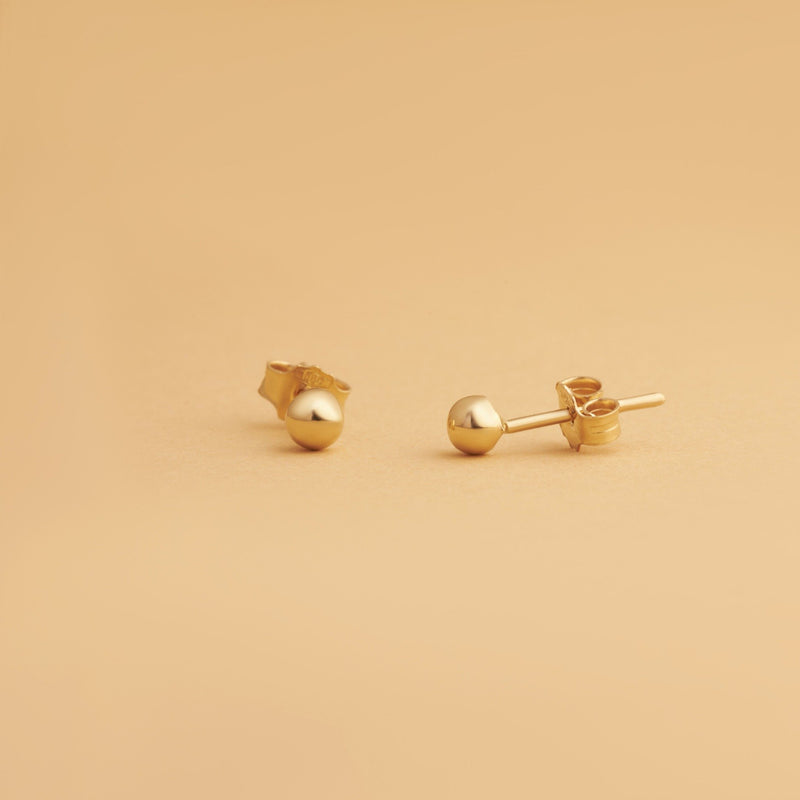 Nock Sfär 3 mm – sfäriska stiftörhängen i 14K guld. Subtil och minimalistisk design perfekt för stacking eller att bäras solo.