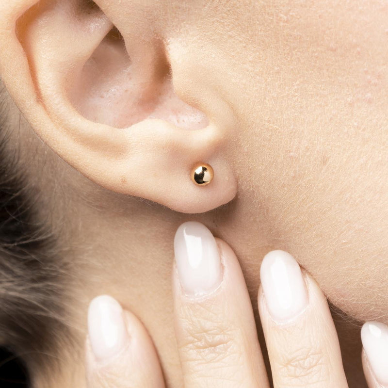 Sfäriska stiftörhängen i 14K guld med tidlös design – minimalistiska och skulpturala, perfekta för daglig elegans. Reflekterande polerad yta och hållbar kvalitet från Nock Studios
